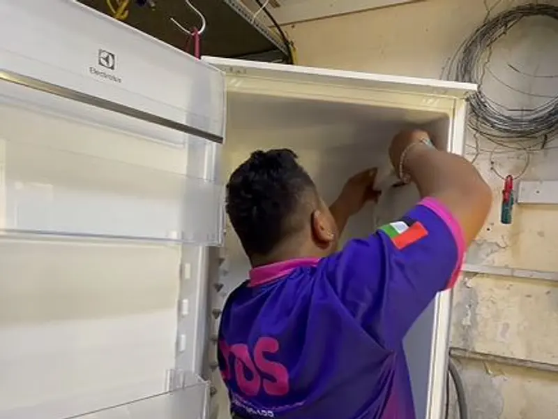 A TopOne technician repairing a fridge compressor