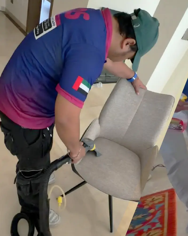 TopOne cleaner using an extraction tool on an upholstered chair