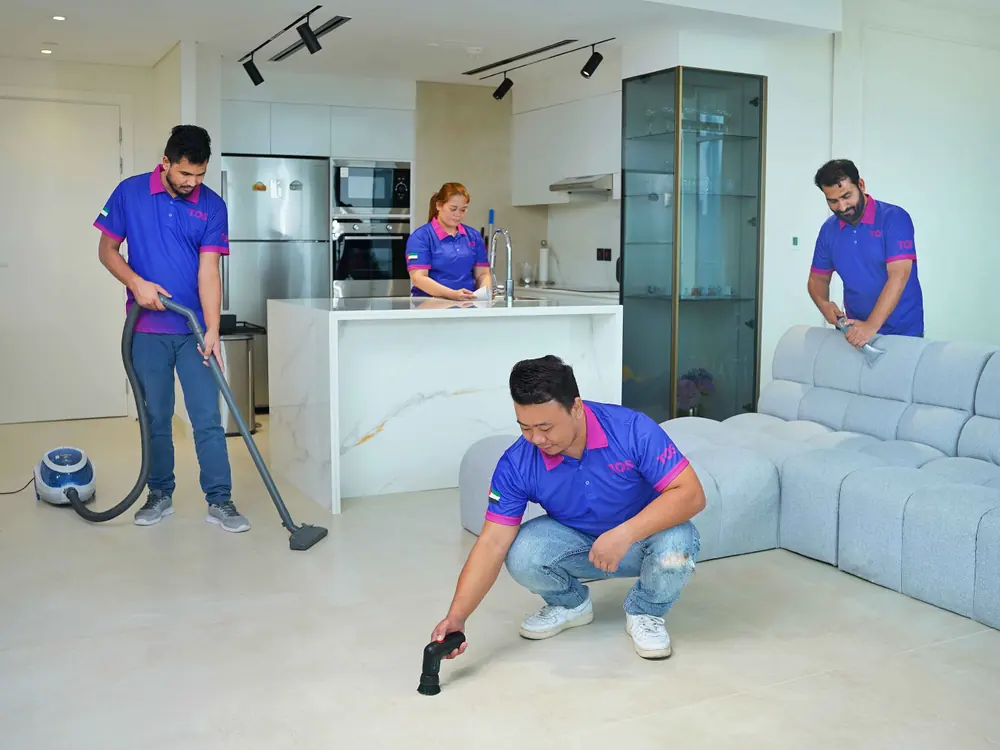 A TopOne team deep cleaning an apartment: floors, kitchen and sofa