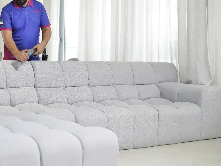 TopOne cleaner steam cleaning a grey tufted sofa