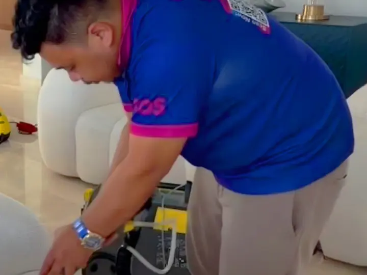 TopOne cleaner using a steam and extraction machine on a white sofa