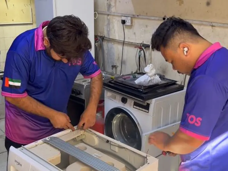 A TopOne technician repairing a washing machine